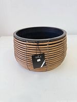 Front view of round bamboo rattan planter with tag