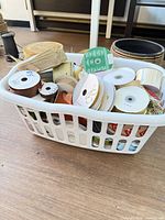 Laundry basket filled with assorted ribbon rolls