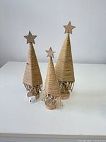 Front view of three jute & wood tabletop Christmas trees showing sizes and star toppers