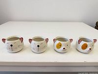 All four ceramic cat face planters front view