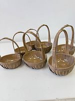 Seven woven reed baskets grouped together