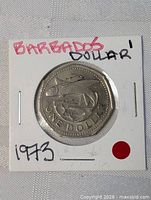 Obverse of Barbados one dollar coin showing flying fish, legend ONE DOLLAR, year marked on flip