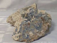 Front view showing blue sodalite patches within beige matrix