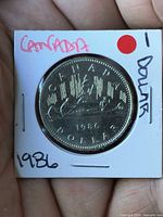 Reverse showing CANADA 1986 DOLLAR canoe design in flip