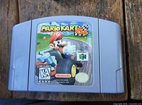 Front view of Mario Kart 64 Nintendo 64 cartridge on wood surface
