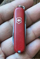 Closed red Victorinox Swiss Army knife showing emblem and keyring