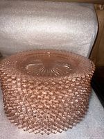 Stack of pink hobnail plates showing pattern and color