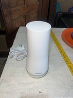 Full view of SimpliSafe siren standing upright with power cord
