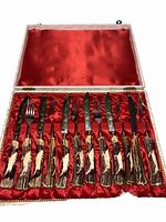 Open presentation box showing full 12-piece set on red satin interior