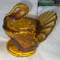 Side view of amber iridescent glass turkey covered dish showing lid and base