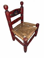 Perspective view showing red wooden chair with rush seat and decorative backrest