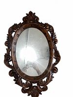 Entire mirror showing carved wood frame and oval glass