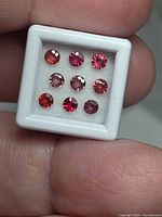Close-up of nine sapphires in display box showing color and clarity