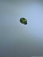 Oval green sapphire on neutral background