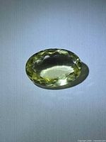 Oval light yellow faceted gemstone front view