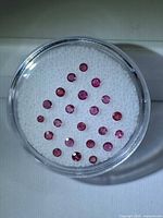 Top-down view of all rubies in clear plastic gem jar