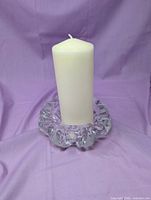 crystal ashtray shown upright with pillar candle for scale
