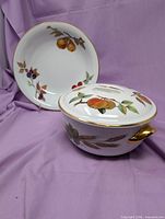 Bowl and covered casserole showing exterior fruit designs and gold trim