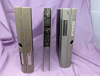 Three binders standing upright showing beige metal spines with finger pulls and label slots