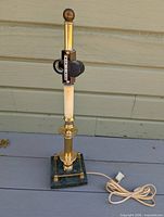 Full view of lamp showing brass column, green stone base, cord