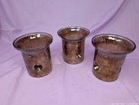 Three amber glass candle holders front view