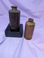 Both stoneware bottles side by side for size and color comparison