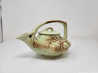 Right side view showing full teapot profile, handle, spout, glaze color