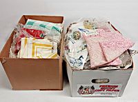 two boxes filled with assorted folded linens