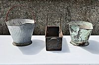 Front view of three metal coal buckets