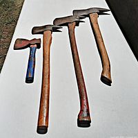 Four axes on white surface angled to show heads and handles