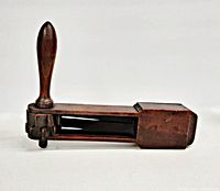 Side view of wooden fire rattle showing handle and body