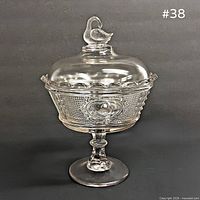Front view of clear glass swan finial compote on pedestal