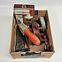 Lot overview inside box showing grinder, handled stone, oilstone, honing kit