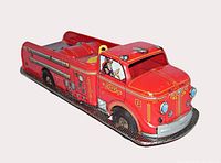 Left front view of red Marx tin fire truck showing cab, graphics and missing ladder deck