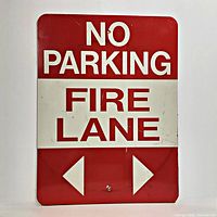 Front of red and white "NO PARKING FIRE LANE" metal sign with arrows