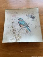 Front view of square glass tile plaque showing bird and floral motif