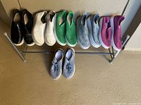 Eight pairs of shoes arranged on rack showing colors and styles