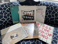 Group shot of all six LPs standing and laying on sofa
