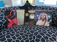 Group shot of four album covers on patterned sofa