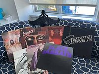 Group shot of seven LP covers on sofa