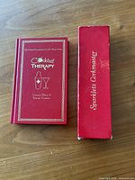 Front view of Cocktail Therapy book beside Sparklets Corkmaster box