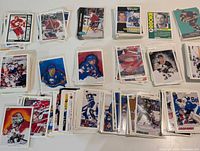 Overview of sorted stacks of hockey trading cards showing variety of sets and players