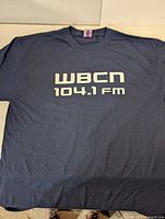 Front of navy T-shirt showing WBCN 104.1 FM logo