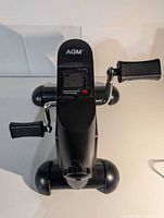 Top view showing AGM logo, LCD display, pedals, stabilizer feet