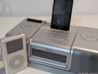 iHome docking speaker with black iPod touch inserted and white iPod Classic standing in front