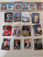 Various stacks of baseball cards laid out showing different fronts and protective sleeves