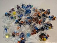 Overview of numerous small plastic bags each holding assorted marbles