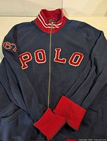Front view showing POLO appliqué, zipper, red cuffs