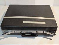 Closed Samsonite briefcase exterior showing tape and wear