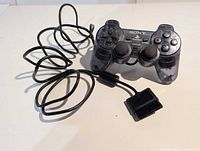 Full view of Sony translucent smoke DualShock controller with cord and connector